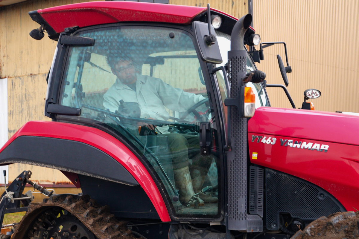 トラクターを操縦するあきた皆別当の草薙さん